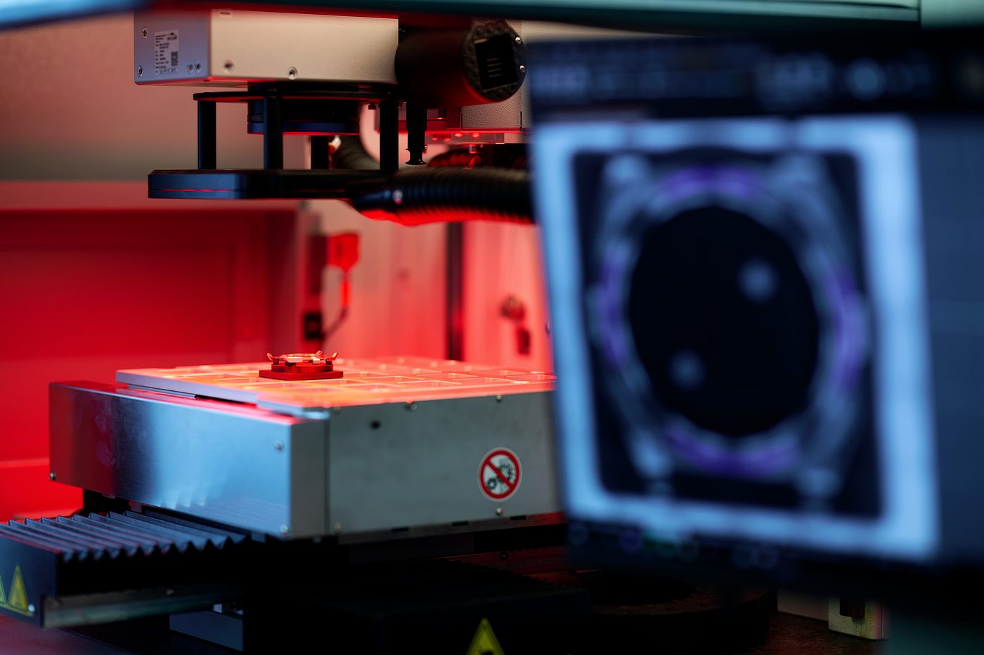 A component on the laser bed, its outline read on the screen alongside.