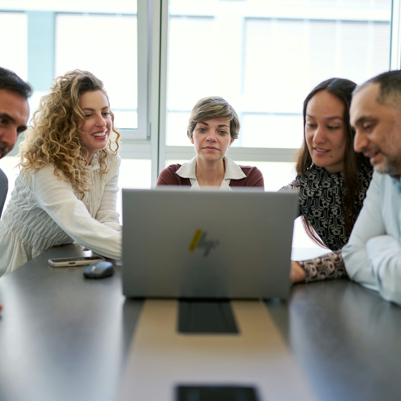 NIRU colleagues gathered around a laptop during a NIRU Academy learning session