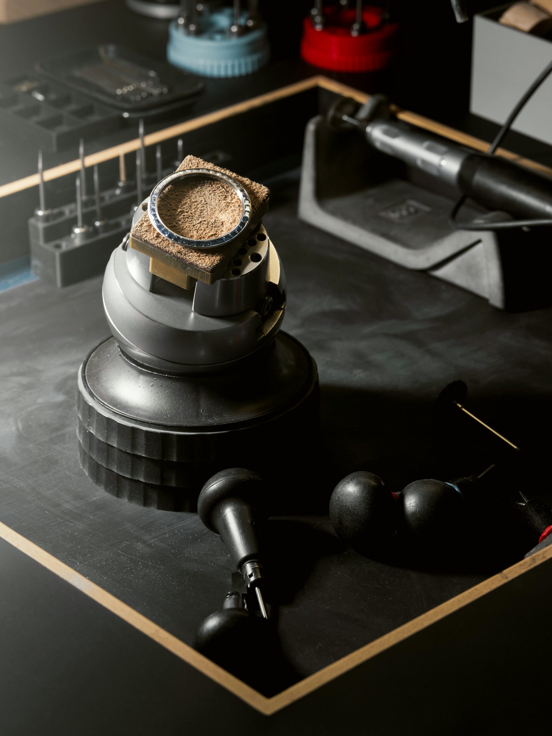 A gem-set watch bezel held on a ball vise at the Geneva manufacturing floor