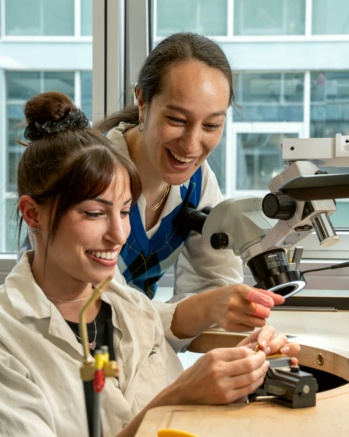 Two NIRU colleagues sharing a laugh over the microscope in Geneva