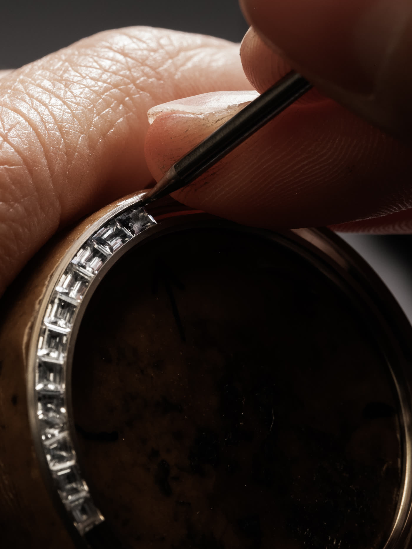 Baguette stones being set into a watch bezel with a pusher