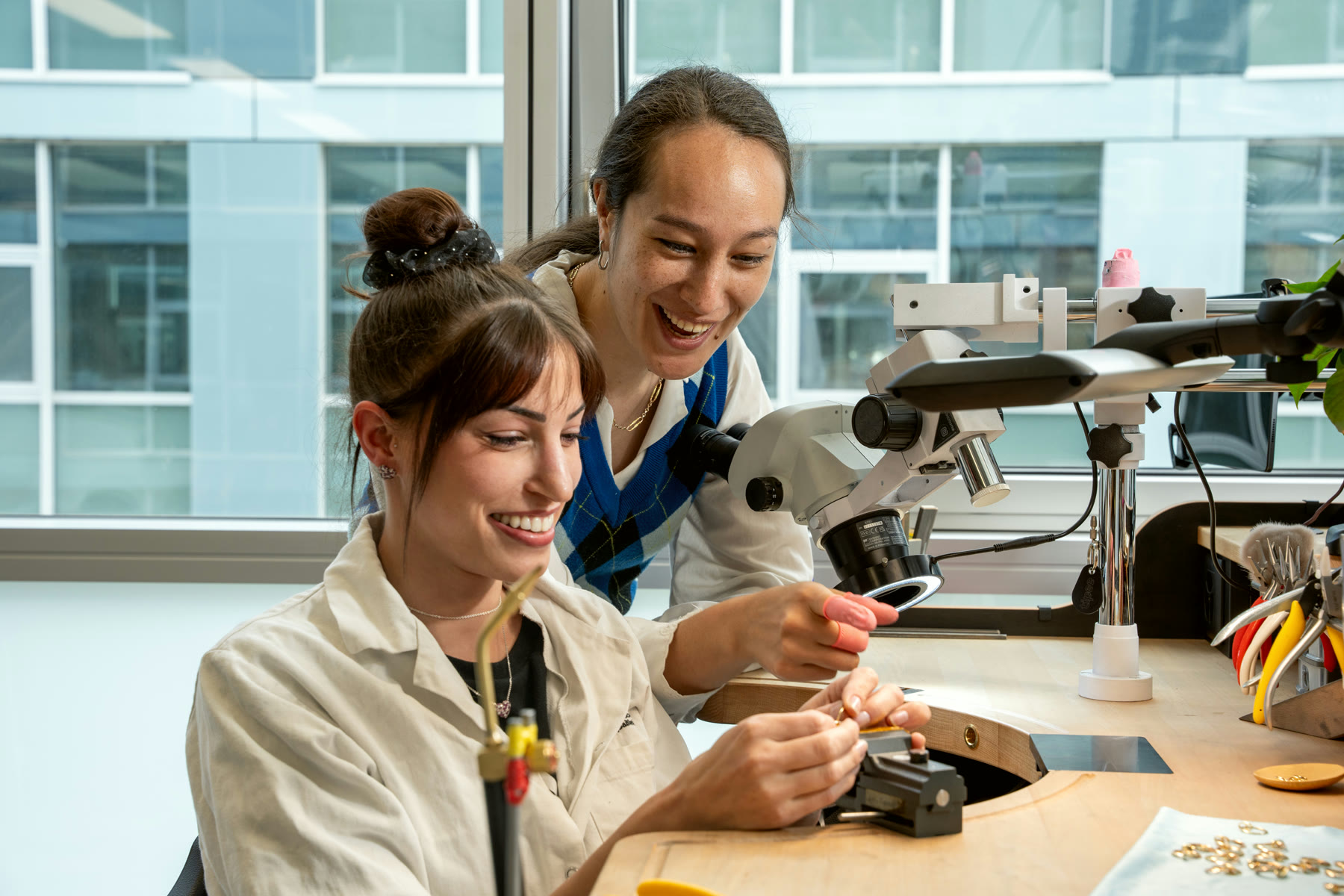 Two NIRU colleagues sharing a laugh over the microscope in Geneva